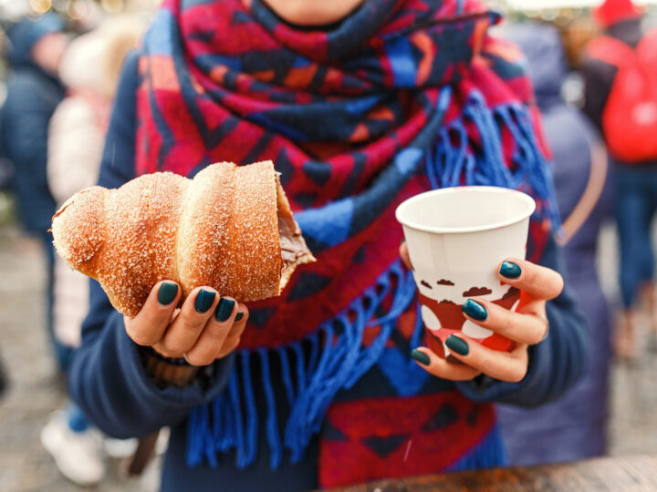 Woman holding czech traditional delicious trdelnik and hot wine closeup
